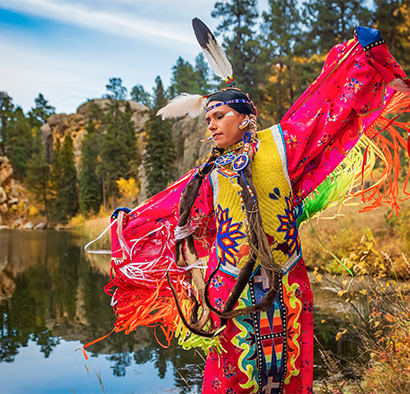 Native American woman in traditional attire dancing
