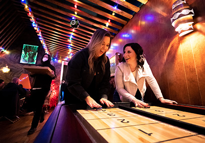 two girls playing shuffle board